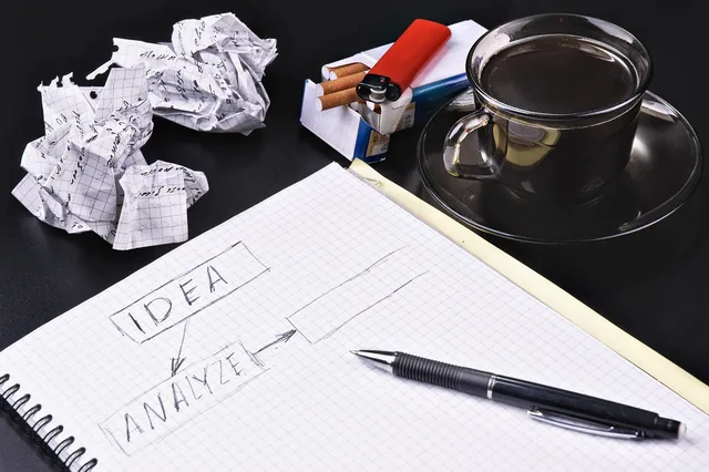 idea, concept, notebook, pencil, crumpled papers, cigarettes, coffee, decision, business, notepad, office, thinking, analyzing. Desk data or real people for keyword research audience research?