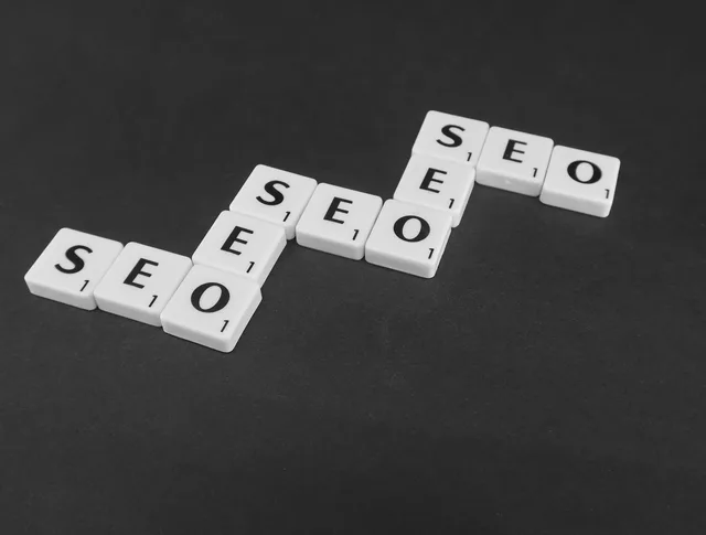 SEO spelled with Scrabble tiles on a black surface, representing search engine optimization concepts. Keyword research review: the two-source scoring rule