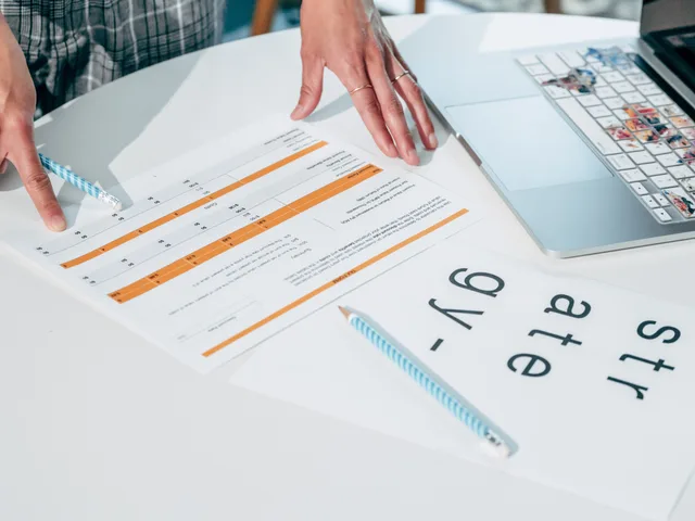 Close-up of hands reviewing business documents and strategy papers on an office desk. How to screen keyword research suppliers and build a shortlist you can defend